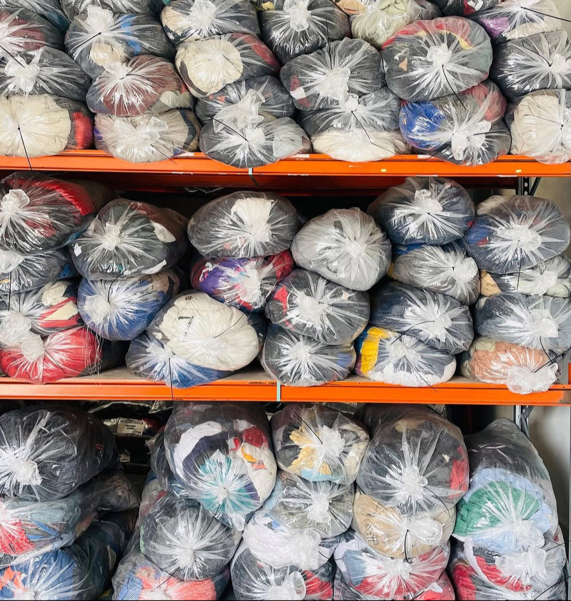 Ballots de vêtements vintage sur étagères, prêts à l’expédition