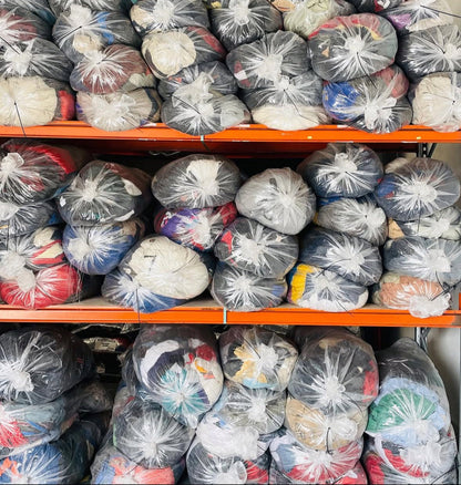 Ballots de vêtements vintage sur étagères, prêts à l’expédition